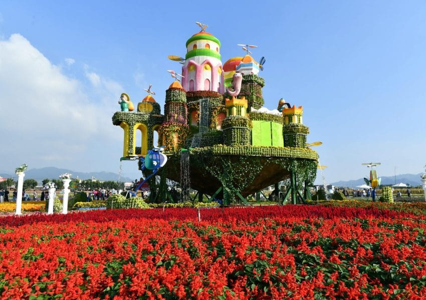 A large flower garden with a castle in the middle